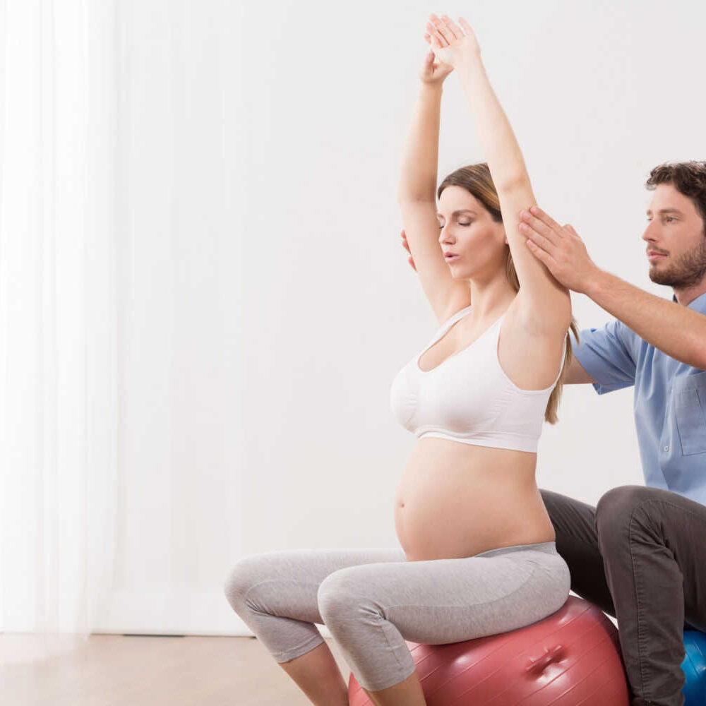 stock-photo-young-pregnant-woman-exercising-at-antenatal-class-336945815